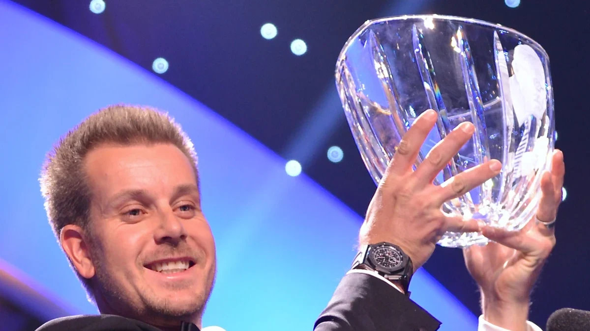 Flagga på green med tävlingsläktare i bakgrunden för profilen om Henrik Stenson